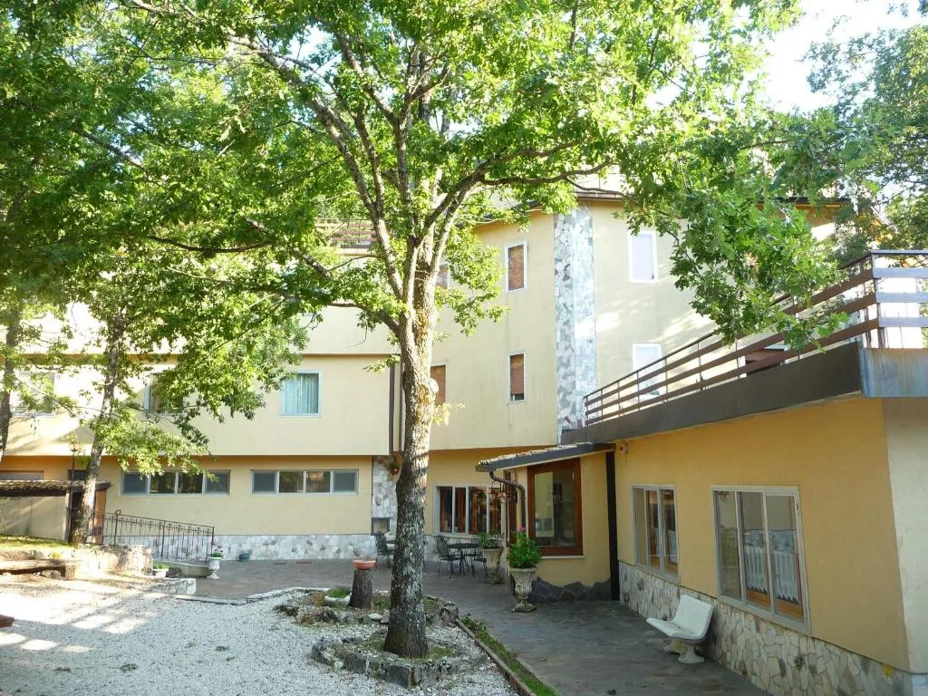 Cortile interno dell'hotel con alberi e terrazza nella stagione estiva